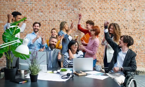 A group of excited entrepreneurs working on project indoors in office, celebrating successful contract.